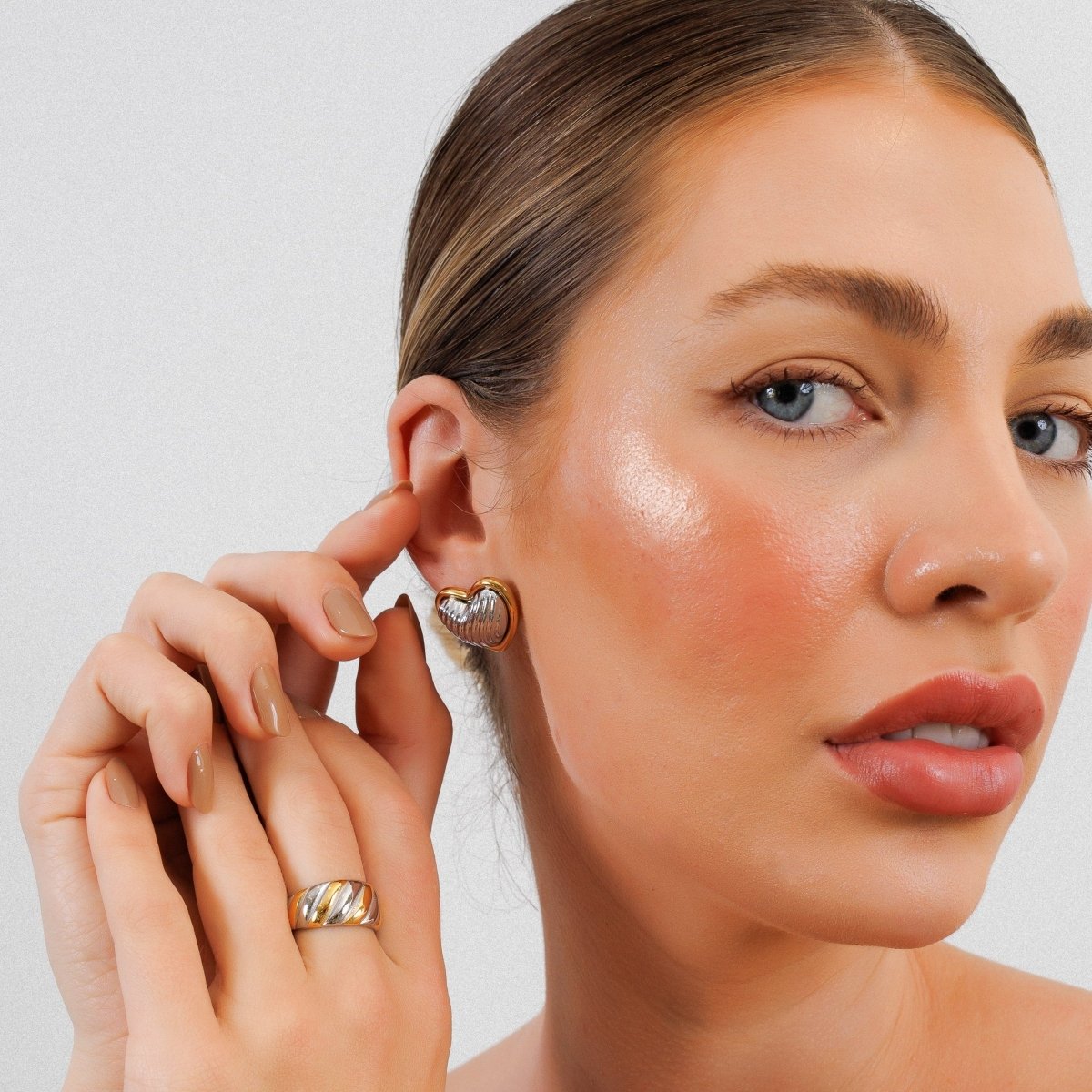 Heart-shaped stud earrings with a mix of gold and silver plating.