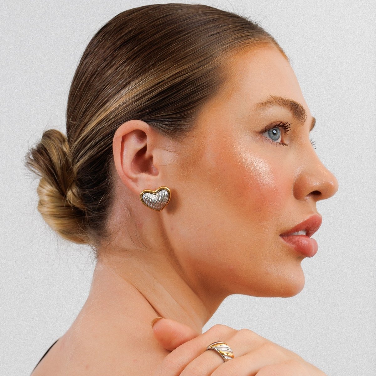 Heart-shaped stud earrings with a mix of gold and silver plating.